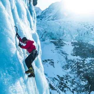 IFMGA guide teaching ice climbing techniques on a frozen waterfall in Chamonix