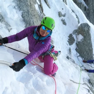 Alpinist using ice tools on a steep mixed section in the Mont Blanc range