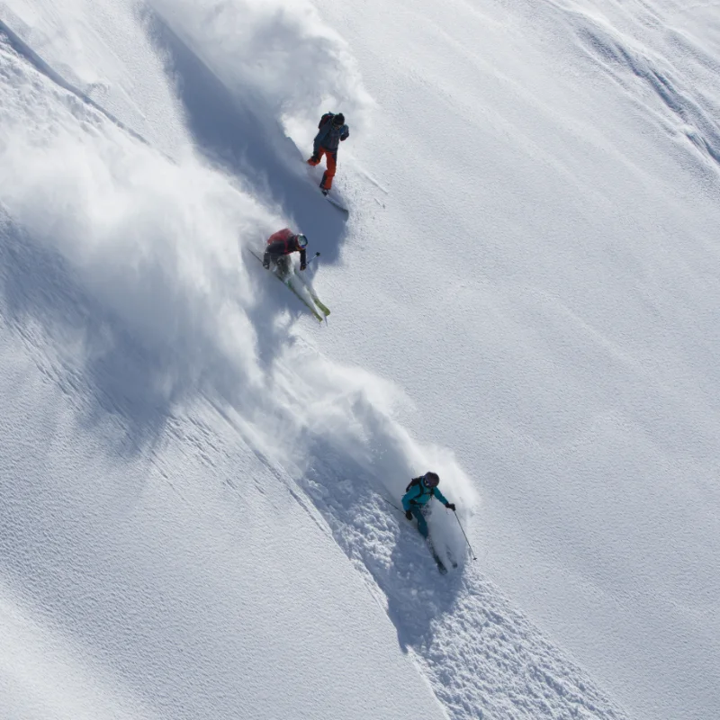 Heliskiers preparing for a powder descent in the high mountains