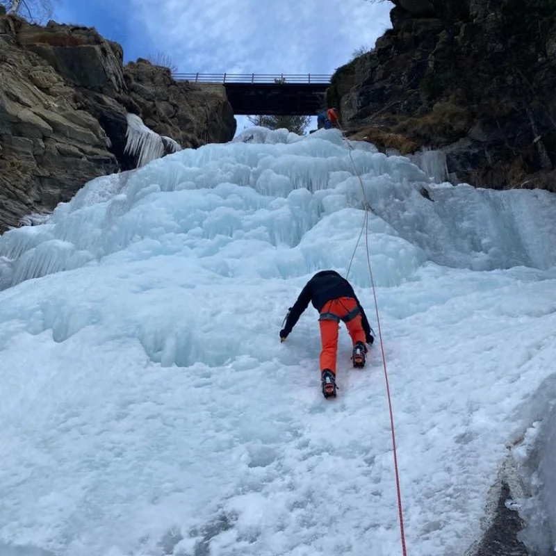 Climber on a frozen waterfall in Cogne Valley during a guided ice climbing experience.