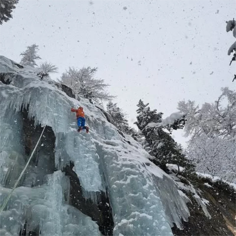 Climber ascending an icefall at La Cremerie in Argentière during a guided ice climbing day.