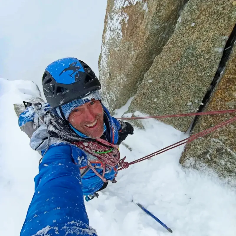 Climber tackling a north face route in winter conditions