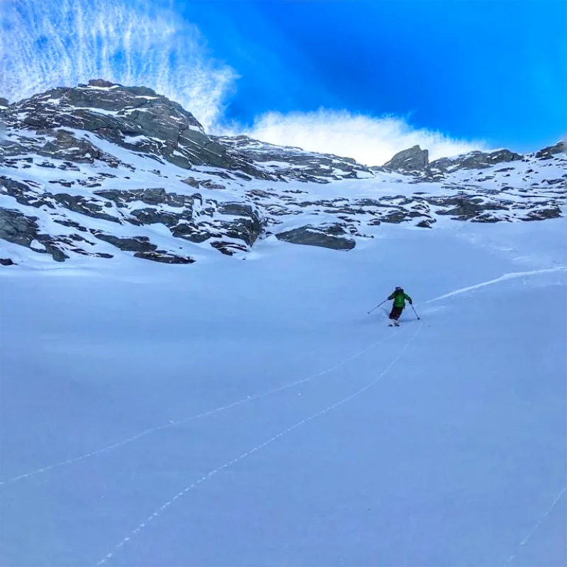 IFMGA guide leading skiers through off-piste terrain near the Aiguille du Midi
