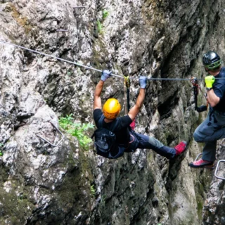 Via ferrata participant crossing a suspension bridge