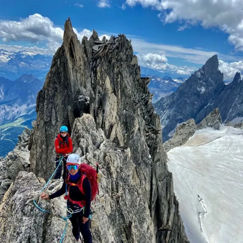 IFMGA guide teaching alpine mountaineering techniques on rocky terrain