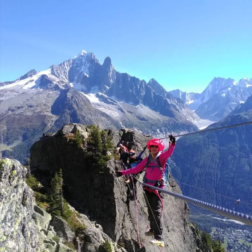 IFMGA guide assisting clients on a protected rock climb