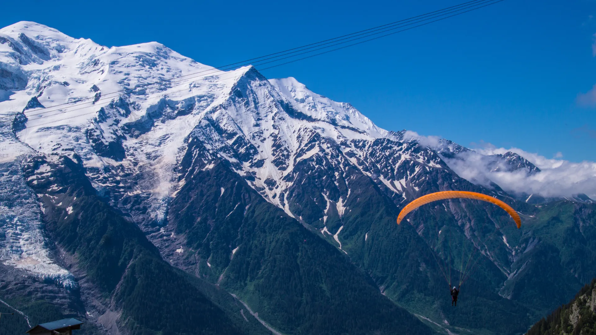 Colorful paraglider wing against a clear alpine sky