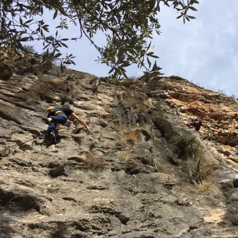 Climber securing protection on a multi-pitch alpine route